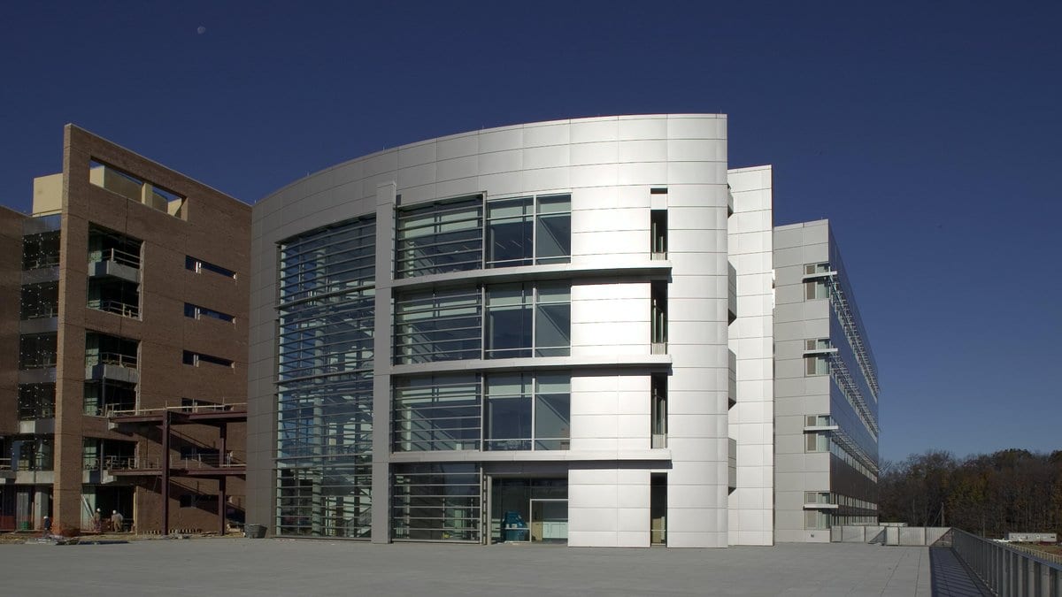 A laboratory building with a curved glass front on the Food and Drug Administration campus in Silver Spring, Maryland, under a clear sky.