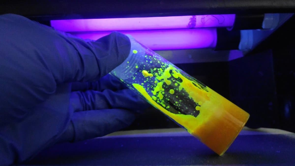 Vials of colloidal quantum dots fluorescing different colours under laboratory light