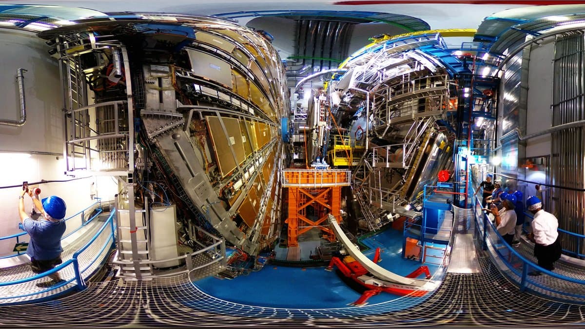 The ATLAS particle detector at CERN's Large Hadron Collider, a large cylindrical instrument surrounded by orange and grey machinery.