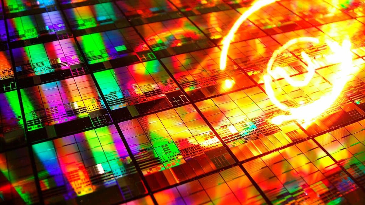 Close view of a 300-millimetre silicon wafer whose surface is tiled with a regular grid of small square integrated-circuit chips, the round wafer edge visible at the margin.